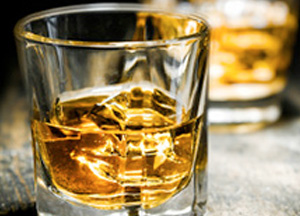Ein gefülltes Glas mit Whisky und Eiswürfel